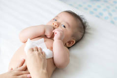 妈妈在换尿布或尿布、擦拭手、脸或腿的时候，用湿巾擦拭和擦拭婴儿的身体