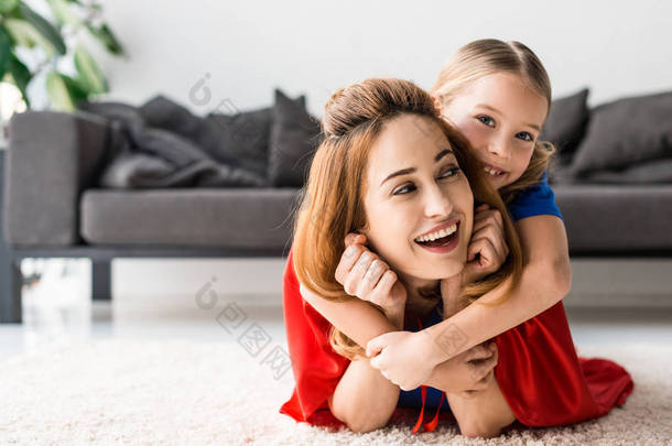 可爱的女儿和<strong>迷人</strong>的母亲拥抱在地板上
