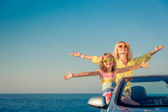 愉快的家庭乘车旅行。人们穿着蓝色的敞篷车玩得很开心。暑假理念