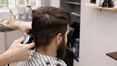 时尚的理发师在理发店理发。胡子男子在沙龙理发.
