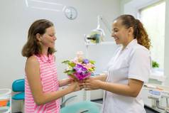 女病人给牙科诊所的一位女医生送了一束鲜花。全国牙医日.