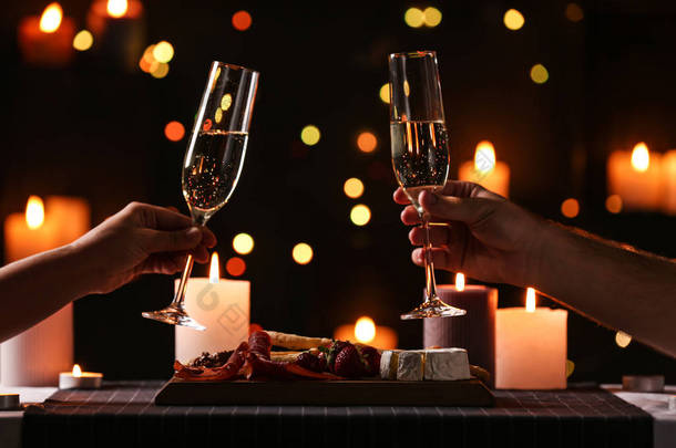 年轻夫妇与香槟酒有浪漫的<strong>烛光</strong>晚餐在餐桌上，特写