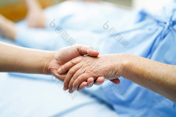 手持触摸手亚洲高级或老年老太太妇女患者关爱、关怀、帮助、鼓励与移情在<strong>护理</strong>医院病房: 健康强的医学概念