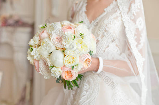 漂亮的结婚花束，手中拿着彩带和<strong>花边</strong>的牡丹，<strong>婚礼</strong>的细节.
