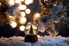 雪地里装饰着圣诞树，雪地里站着云杉枝条，夜晚灯光朦胧