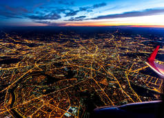 俄罗斯莫斯科的空中景观，蓝色时辰的街道灯火通明- -飞机引擎和机翼，右下角可见翼