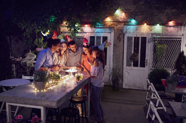 group of young adults celebrating a birthday party at outdoor ca