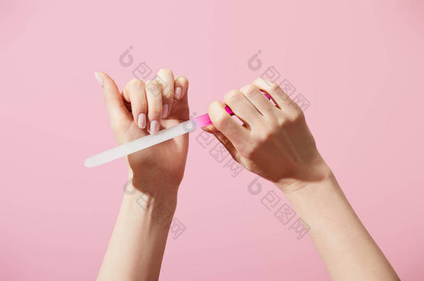 用粉色隔断的指甲文件记录指甲的妇女的剪影