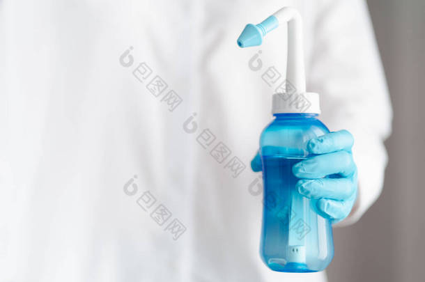 医生与蓝色水脉鼻腔冲洗瓶，鼻腔刺激概念