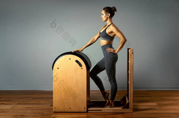普拉提、健身、运动、训练和人的概念- -女人在小桶上做运动.<strong>矫正</strong>器，<strong>矫正</strong>器.