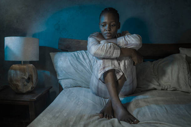 年轻、悲伤、沮丧的非洲裔美国妇女在家里躺在床上，很<strong>不</strong>快乐，晚上<strong>睡不着</strong>觉，感到难以忍受的忧郁症和失眠