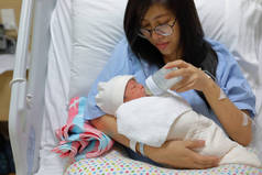 母亲养育，母亲用奶瓶喂哺婴儿喝母乳