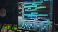现代音乐录音演播室设备：电脑屏幕显示的用户接口，数字音频工作站软件的轨道歌曲播放。声音及音乐记录及编辑应用