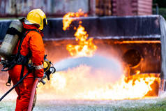 消防员使用化学泡沫灭火器与油罐车事故产生的火焰作战。消防员安全、灾害、事故和公共服务概念.