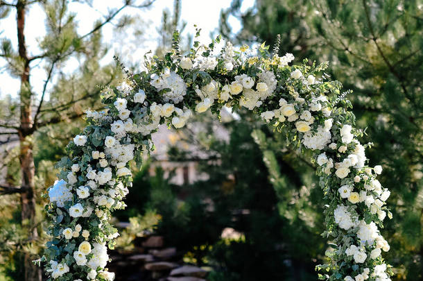 户外婚礼布置，婚礼拱门上饰有淡淡的白花