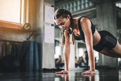 年轻迷人的健身女子在健身房用机器进行运动的电影基调。适合身体肌肉的个人运动促进健康生活理念. 