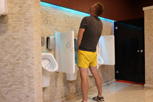 穿着黄色羊毛衫的男人在公厕画像里撒尿