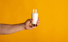 千年前的人，手拉手紧紧地拿着一杯橙黄色背景的牛奶