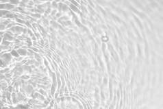模糊的、透明的、透明的、清晰的、平静的水面纹理，带有水花和气泡。潮流抽象的自然背景.阳光下的白灰水波。复制空间.
