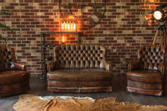 客厅里昂贵的装饰。靠墙的皮革沙发和椅子