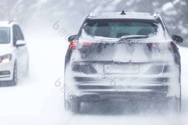 <strong>越野车</strong>在森林里雪地滑的路上行驶，由于下雪，车牌号难以辨认.