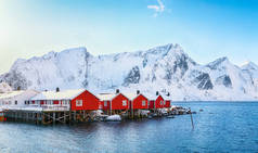 Hamnoy村附近Reinefjorden海岸上传统的挪威红木房子（rorbuer） 。地点：Hamnoy, Lofoten；Norway, Europe