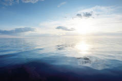 日落时，波罗的海上空蓝蓝的天空闪烁着卷云和积雨云。Idyllic海景。旅行，航行，游轮，娱乐，度假。水中的对称反射，天然镜
