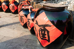 古代陶瓷风格的罐子黑色罐子中国风格的字米酒在中文的红纸上。临兴古瓷中国风格瓷制葡萄酒水罐容器.