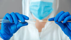 Covid19pcr测试在护士手中.身着防护服的医生戴着医用口罩手套，在实验室里拿着唾液样本进行诊断。鼻咽培养pcr测试。Web Banner.