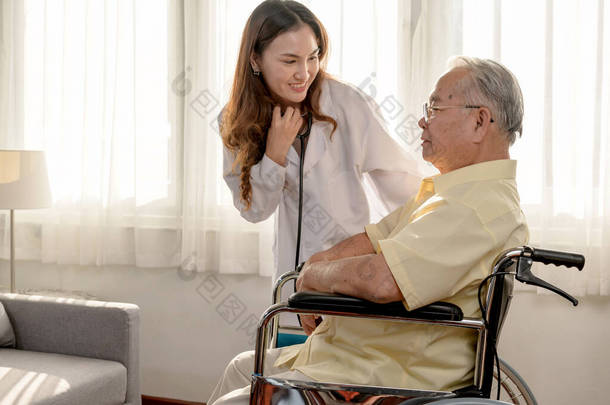 亚洲老人病了，坐在轮椅上。医生检查家里的退休年龄健康状况.
