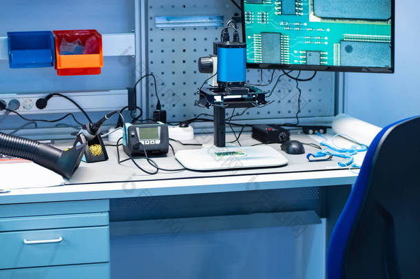一个无线电电子工程师的工作场所。与显示器连接的焊铁、萃取罩和电子显微镜.生产电子元件。实验室生产多氯联苯.