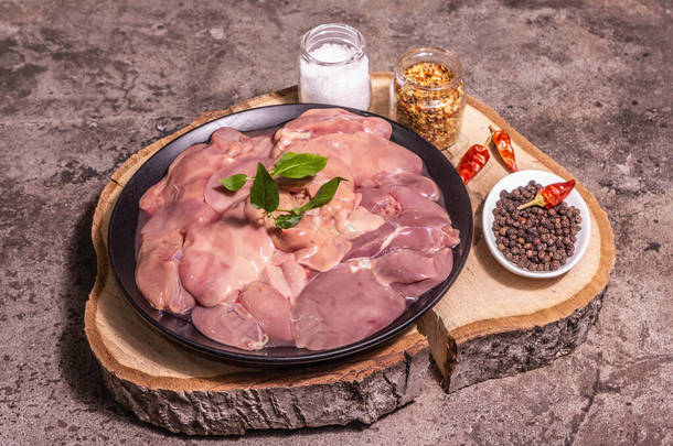 Raw chicken <strong>live</strong>r. A useful ingredient for preparing healthy food. Spice set, wooden stand. Trendy c