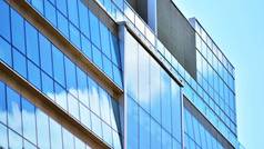 现代建筑覆盖在反射式玻璃板玻璃上的玻璃外墙的抽象特写。建筑的抽象背景。玻璃墙和立面细节.