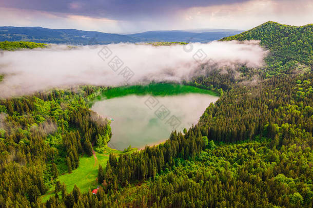 圣安火山湖空中摄影位于罗马尼亚哈基塔县。摄影是在与湖面上空云层相同高度的无人机上拍摄的，摄影角度较低.