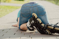 一个男孩带着溜冰鞋从地上摔了下来，想从地上爬起来。骑自行车或过山车的男孩,摔了一跤伤了腿