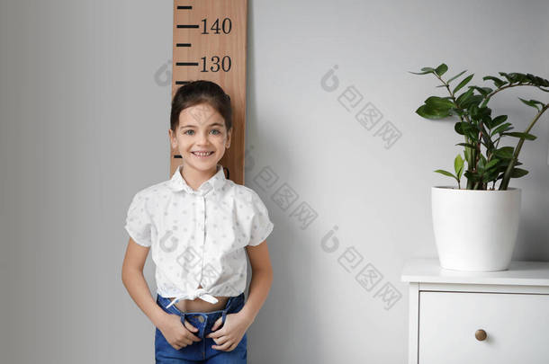 小女孩在家里测量身高
