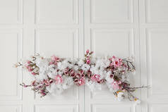 白色背景上的花墙装饰。老式木墙上的白色和粉色花朵