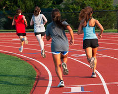 夏令营练习赛期间一群高中女生在跑道上跑得很快的背景图.