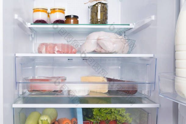 在玻璃柜和抽屉里，在白色的冰箱里，有产品、<strong>全鸡</strong>、肉、鱼、香肠、奶酪、酸奶和新鲜蔬菜