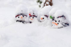 五个可爱的小雪人，头戴帽子，头戴围巾，头戴胡萝卜鼻子，头戴新雪。冬季雪地风情