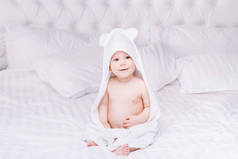 婴儿躺在床上的白毛巾 adorably。快乐的童年和医疗保健概念.