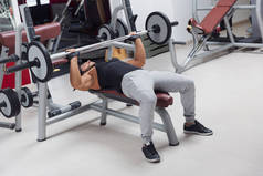 举重或健美运动员躺在板凳上, 在健身房锻炼身体的杠铃重量, 训练时健康活跃的生活方式和健身观念