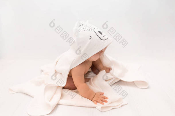 洗完澡后,把宝宝放在粉色<strong>毛巾</strong>下,配上帽子. 宝宝在<strong>毛巾</strong>里。 儿童肖像。 保健概念.