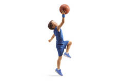 一个穿着蓝色球衣的男孩和一个被白色背景隔离的篮球一起跳的全身像照片