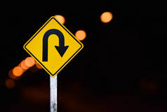 交通标志：在白云蓝色背景的农村公路旁边的水泥杆上右转U型标志，复制空间.