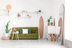 轻便客厅内饰木制冲浪板、沙发及室内植物