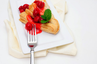 樱桃营业额和薄荷樱桃营业额与一流的樱桃而且红色的樱桃酱汁服务白色矩形飞碟而且光彩色的餐巾