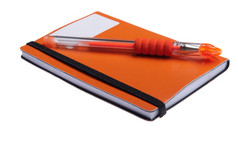 橙色笔记本日记议程而且橙色笔说谎的前孤立的白色背景