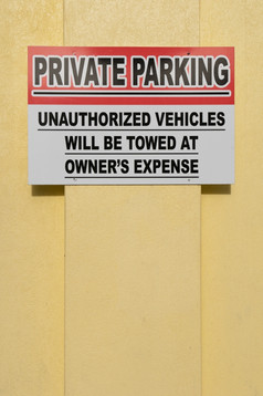 私人停车标志挂黄色的墙