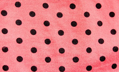 粉红色的波尔卡点织物为背景